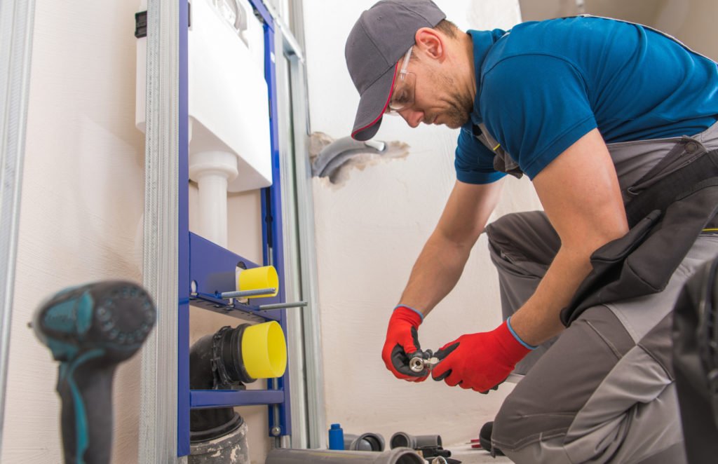 A man doing gas pipe installation indoor